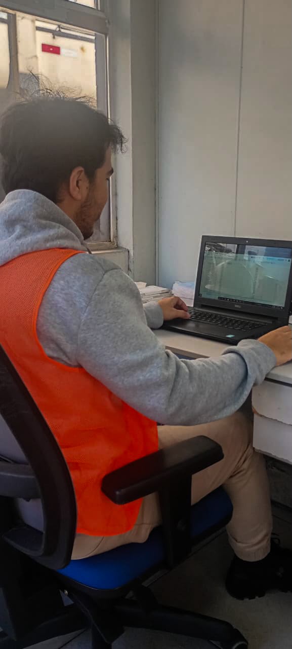 Assistente operacional registrando dados da operação portuária no computador